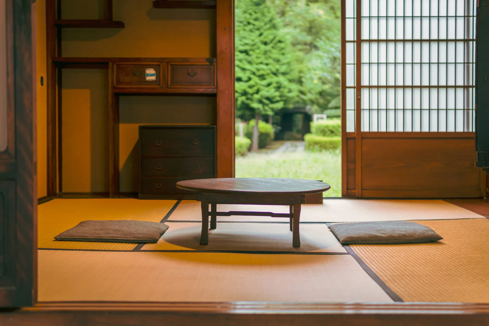 朝の光が差し込む日本家屋の居間。座卓と座布団だけが置かれ、人の姿はない