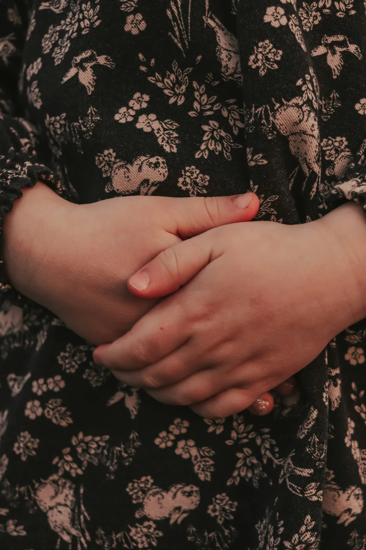 お腹の前で両手を組んで押さえている胸から下の構図