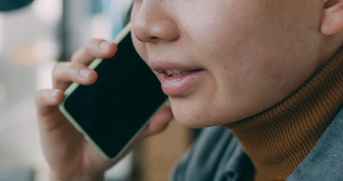 スマートフォンを耳に当てて話している人