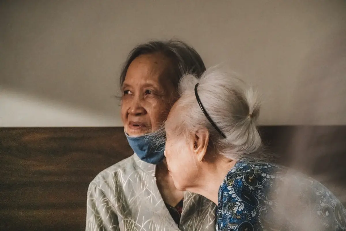 80代の女性と、そのそばに寄り添う家族の様子