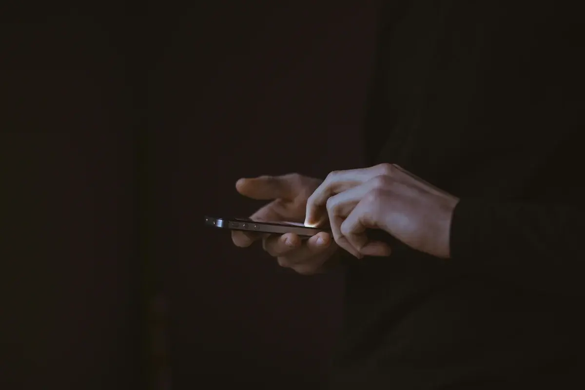 スマートフォンを手に持つシルエット