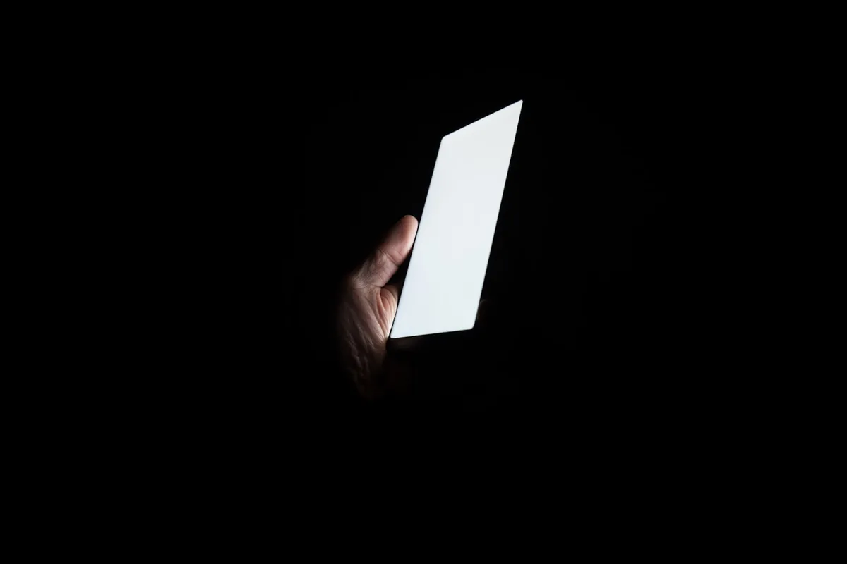 暗闇の中で、手に持ったスマートフォンの画面だけが光っている